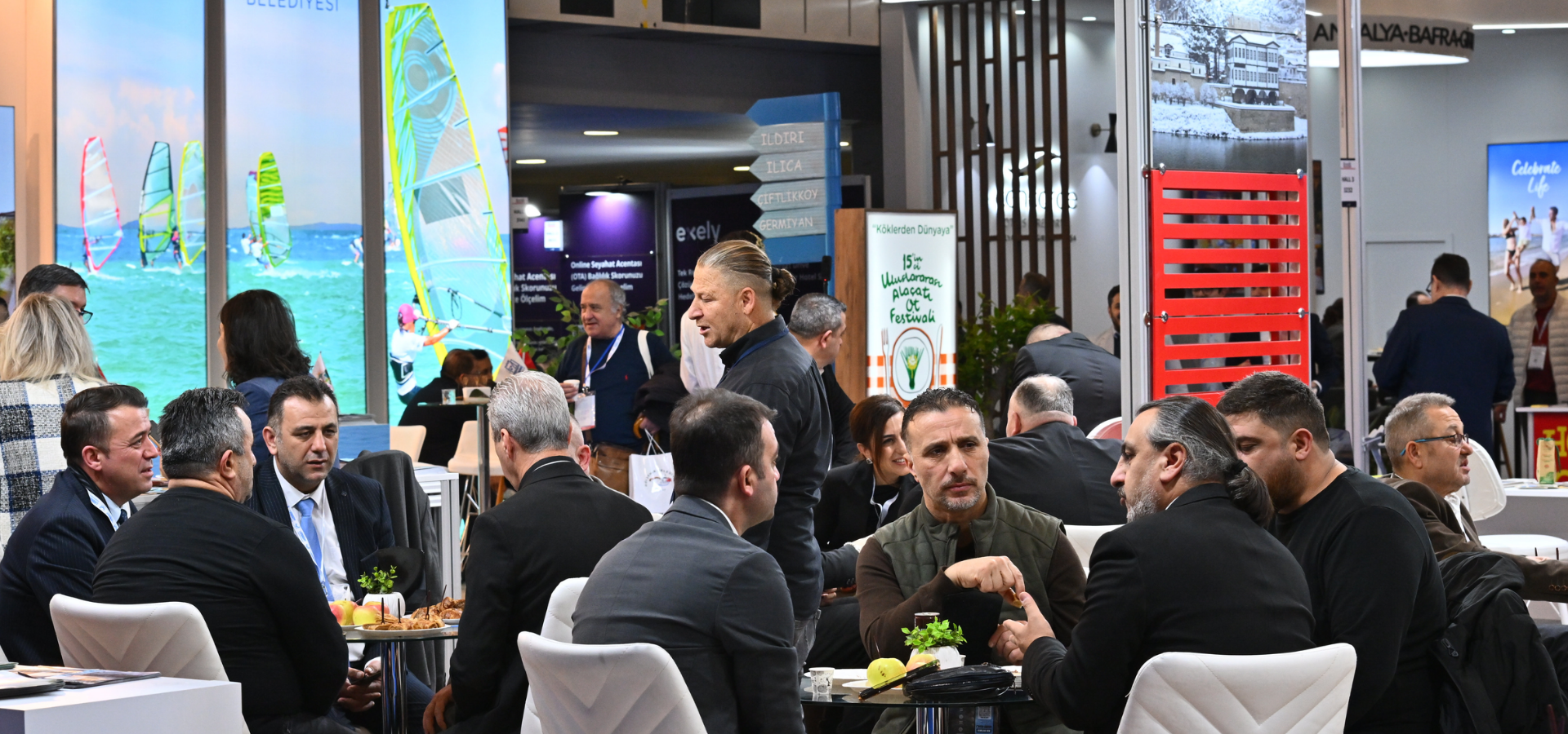 A busy EMITT exhibition aisle with international participants holding B2B meetings